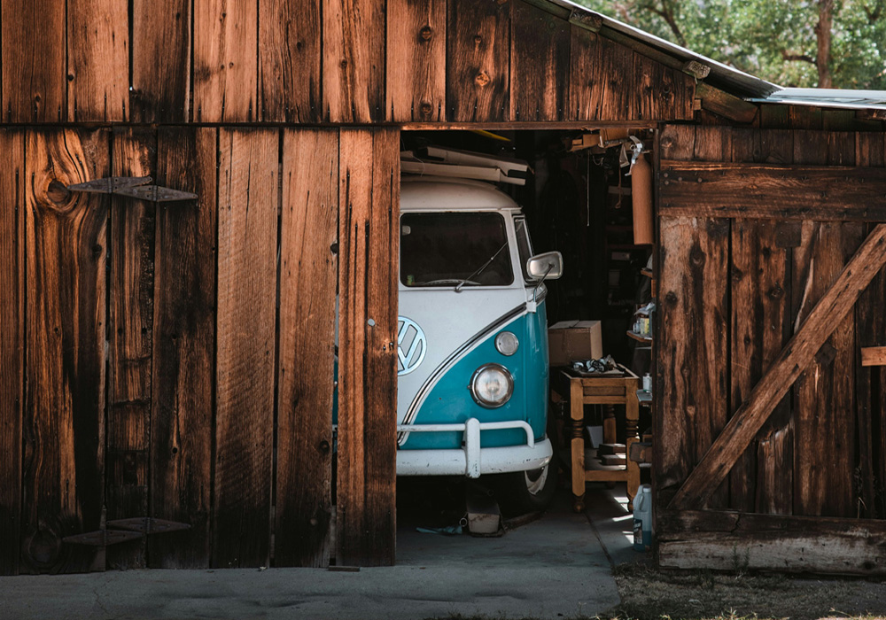 Vintage Volkswagen Bus parked inside a rustic wooden shed